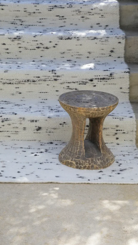 Wool rug with carved stool